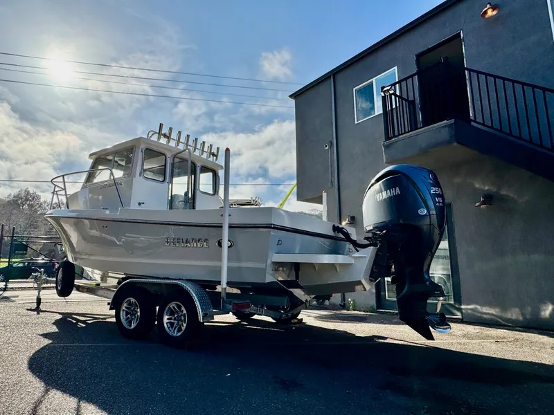 Slide: The Image of 2025 Defiance Admiral 220 EX boat on trailer, parked outdoors under a sunny sky. - 3