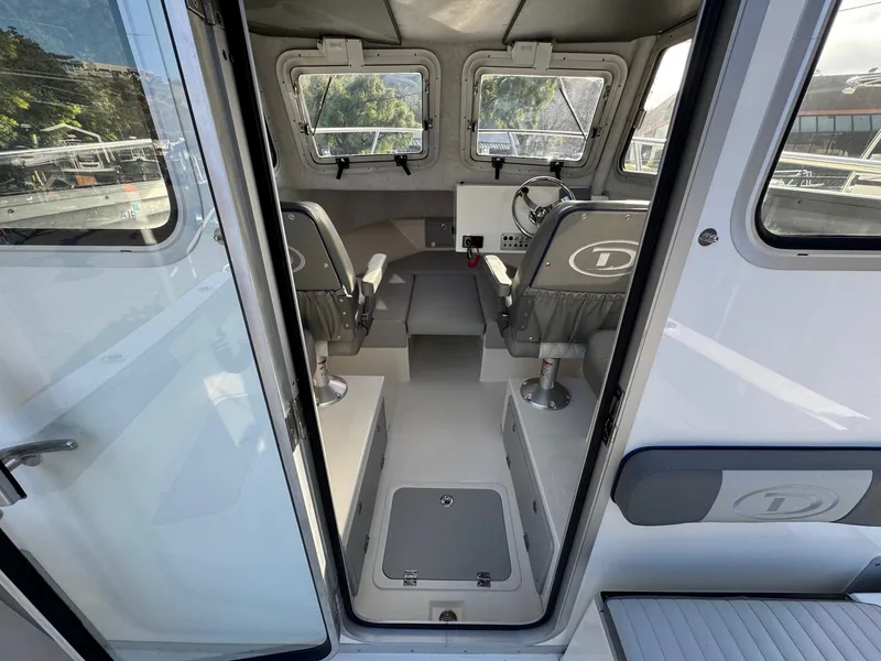 Slide: The Image of Interior view of 2025 Defiance Admiral 220 EX boat, featuring seating and control area. - 30