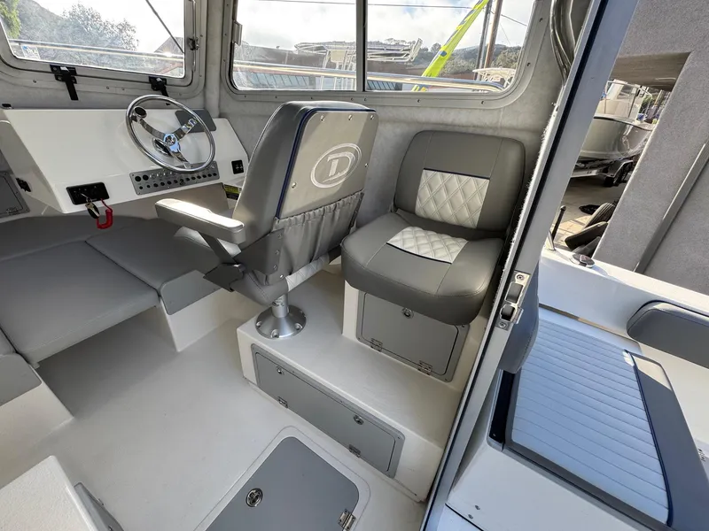 Slide: The Image of Interior of 2025 Defiance Admiral 220 EX boat, featuring modern seating and steering area. - 31