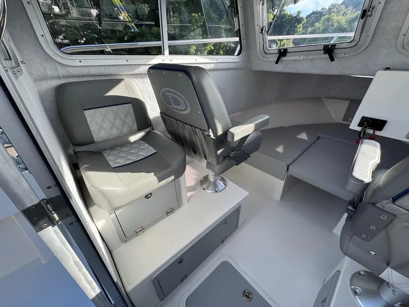 Slide: The Image of Interior of 2025 Defiance Admiral 220 EX boat, featuring modern seating and storage. - 32