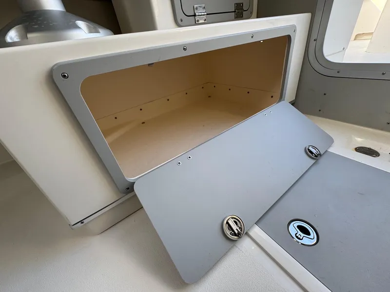 Slide: The Image of Storage compartment in 2025 Defiance Admiral 220 EX boat, open with visible interior. - 37