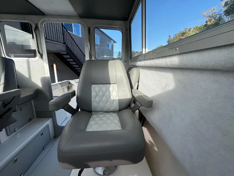 Slide: The Image of Interior of 2025 Defiance Admiral 220 EX boat, featuring a cushioned captain's chair. - 42