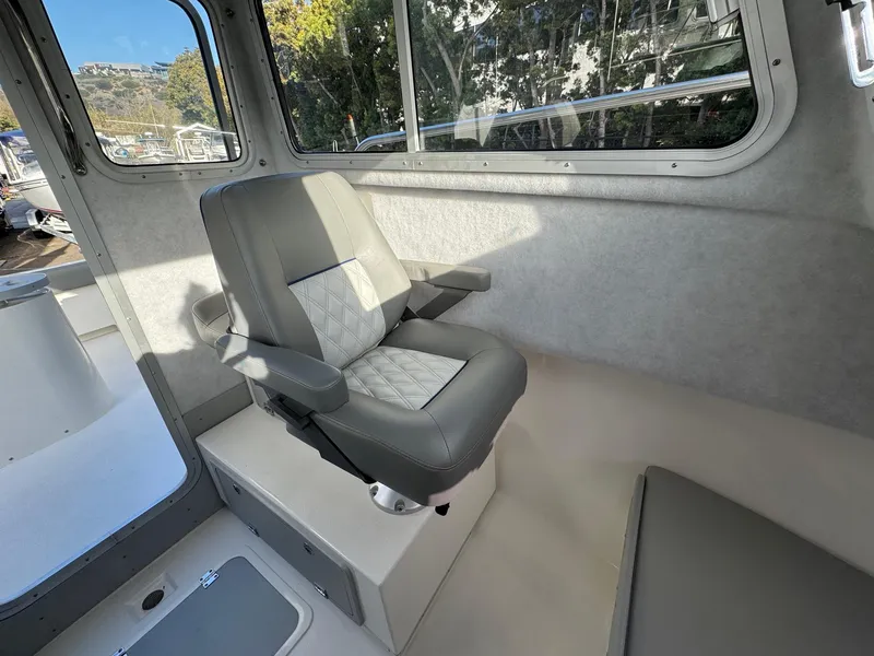 Slide: The Image of Interior of 2025 Defiance Admiral 220 EX boat with a cushioned seat. - 43