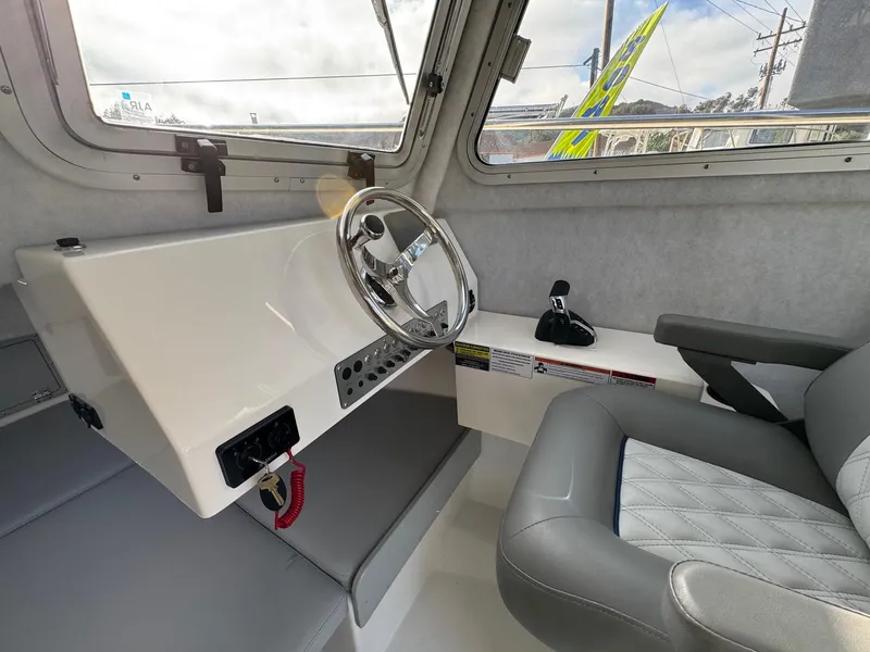 Slide: The Image of Interior of 2025 Defiance Admiral 220 EX boat, featuring steering wheel and seating. - 45