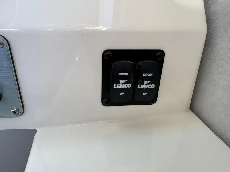 Slide: The Image of Lenco trim tab controls on 2025 Defiance Admiral 220 EX boat dashboard. - 47