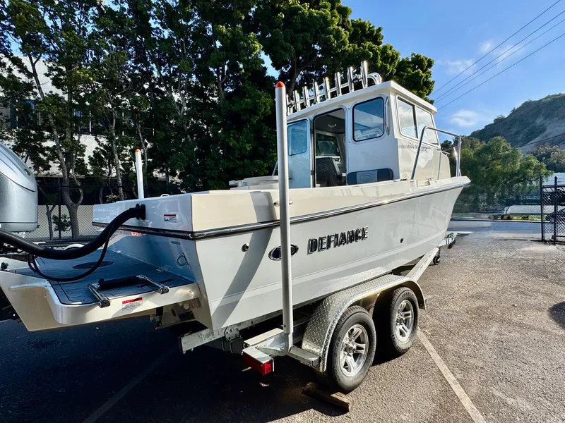 Slide: The Image of 2025 Defiance Admiral 220 EX boat on trailer, parked outdoors, sunny day. - 8