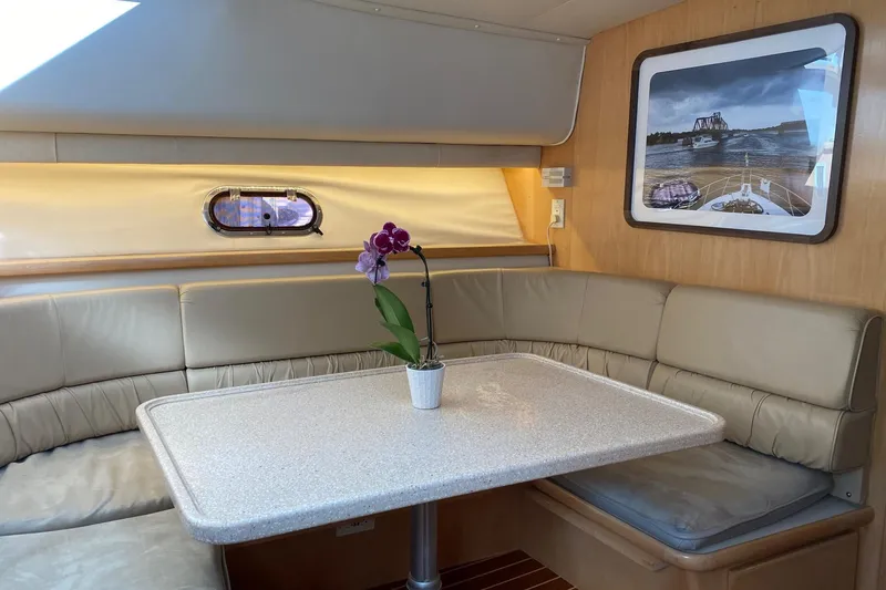 Slide: The Image of Interior of 1998 Carver 445 Aft Cabin Motor Yacht with dining area and orchid centerpiece. - 24