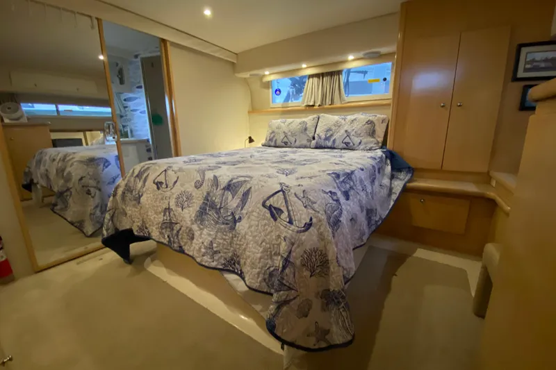 Slide: The Image of Luxurious 1998 Carver 445 Aft Cabin Motor Yacht bedroom with nautical-themed bedding. - 29