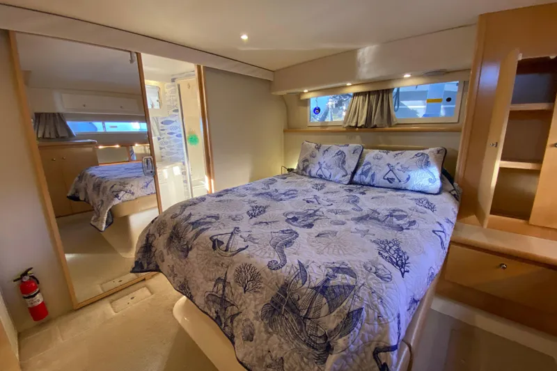 Slide: The Image of Luxurious 1998 Carver 445 Aft Cabin Motor Yacht bedroom with nautical-themed bedding. - 30