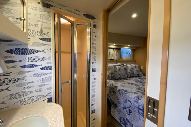 Slide: The Image of 1998 Carver 445 Aft Cabin Motor Yacht interior with nautical-themed decor and cozy bedroom. - 34