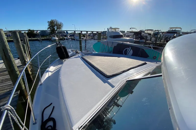 Slide: The Image of 1998 Carver 445 Aft Cabin Motor Yacht docked, sunny day, paddleboard on deck. - 5