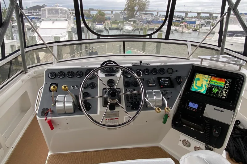 Slide: The Image of 1998 Carver 445 Aft Cabin Motor Yacht helm with navigation equipment and steering wheel. - 15