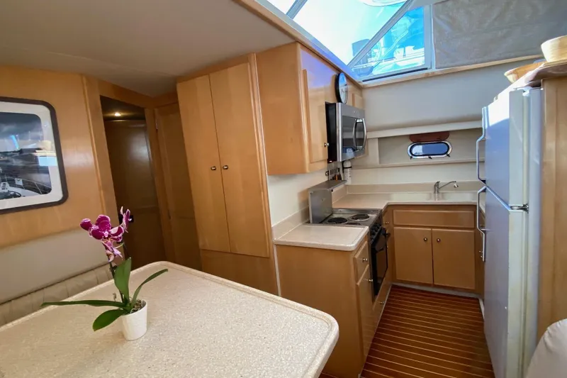Slide: The Image of 1998 Carver 445 Aft Cabin Motor Yacht interior with kitchen and dining area. - 27