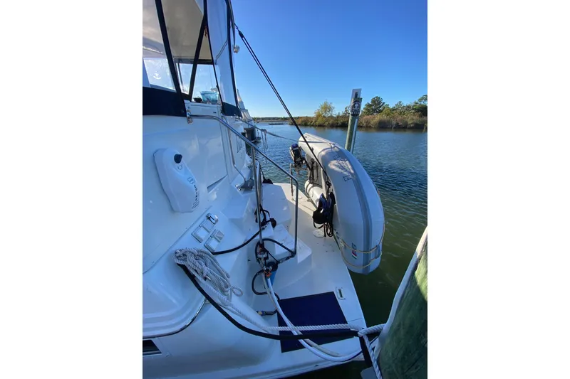 Slide: The Image of 1998 Carver 445 Aft Cabin Motor Yacht docked, featuring a dinghy and clear blue sky. - 3