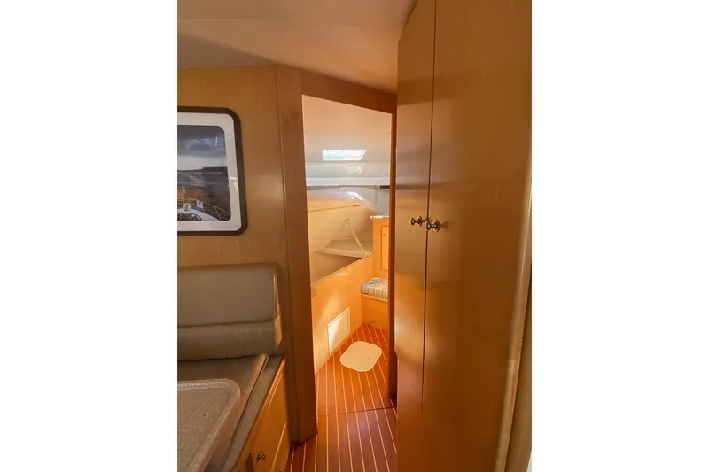 Slide: The Image of Interior of 1998 Carver 445 Aft Cabin Motor Yacht, featuring wood paneling and cozy seating. - 36