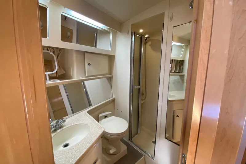Slide: The Image of 1998 Carver 445 Aft Cabin Motor Yacht bathroom with shower, sink, and storage cabinets. - 40