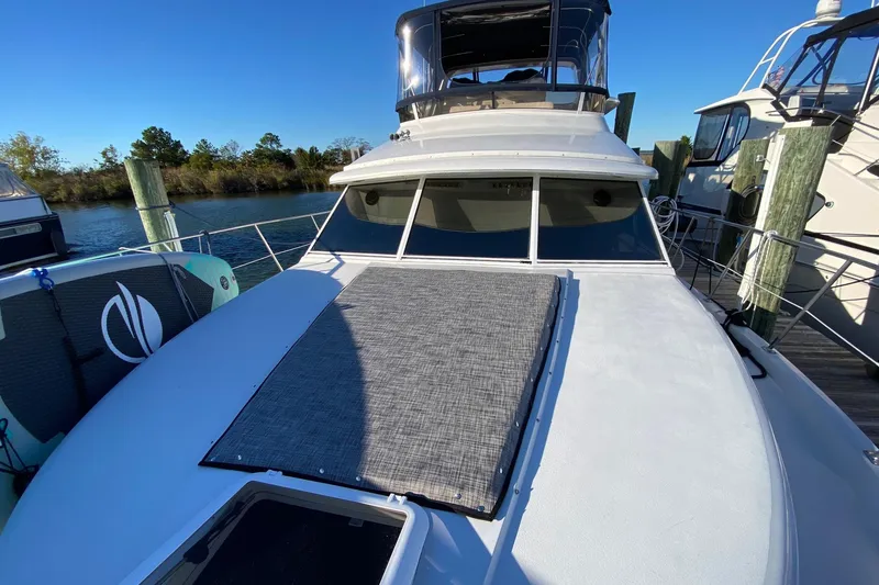 Slide: The Image of 1998 Carver 445 Aft Cabin Motor Yacht docked, featuring spacious deck and sleek design. - 6