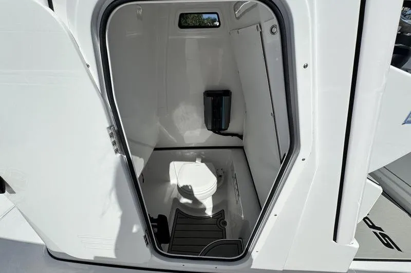 Slide: The Image of 2026 Sportsman Open 262 Center Console boat interior with compact marine toilet. - 15