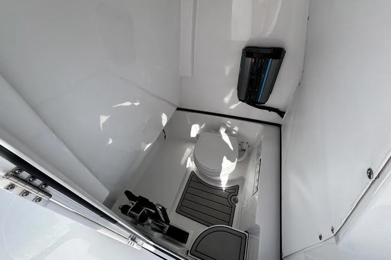 Slide: The Image of 2026 Sportsman Open 262 Center Console boat interior with compact marine toilet. - 16