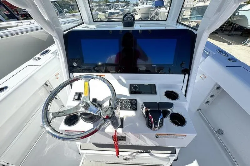 Slide: The Image of 2026 Sportsman Open 262 Center Console boat dashboard with steering wheel and dual screens. - 20