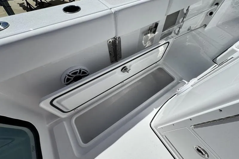 Slide: The Image of 2026 Sportsman Open 262 Center Console boat interior with storage compartment open. - 26