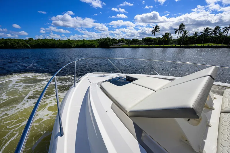 Slide: The Image of 2022 Tiara Yachts 43 LE cruising on a sunny day with palm trees in the background. - 23