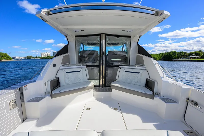 Slide: The Image of 2022 Tiara Yachts 43 LE interior with seating, overlooking serene water and blue sky. - 27