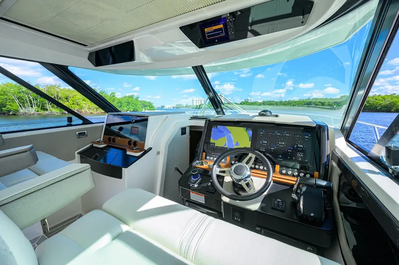 Slide: The Image of 2022 Tiara Yachts 43 LE helm with advanced navigation systems and scenic water view. - 38