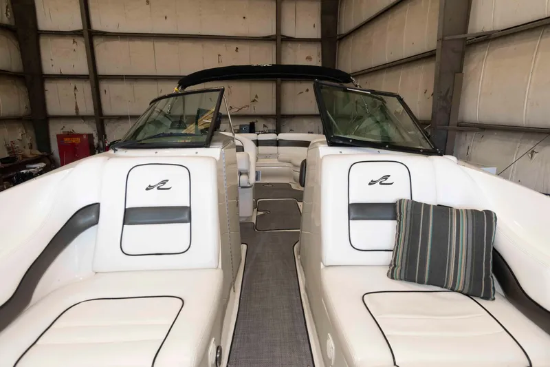 Slide: The Image of 2006 Sea Ray 290 SLX boat interior with white seating and striped cushion in a storage facility. - 11