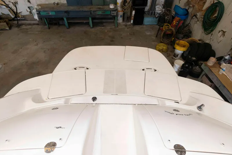 Slide: The Image of 2006 Sea Ray 290 SLX boat in a workshop, showing the rear deck and storage compartments. - 15