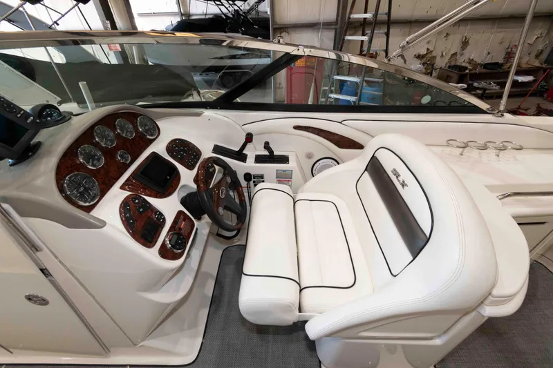 Slide: The Image of Interior of 2006 Sea Ray 290 SLX boat with steering wheel and dashboard controls. - 9