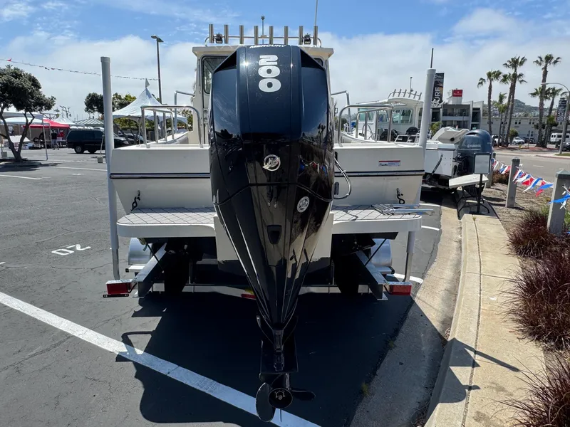 Slide: The Image of 2023 Defiance Admiral 220 EX boat docked at a marina under clear blue skies. - 10