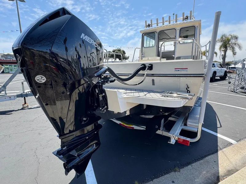 Slide: The Image of 2023 Defiance Admiral 220 EX boat docked in a marina under clear blue skies. - 11