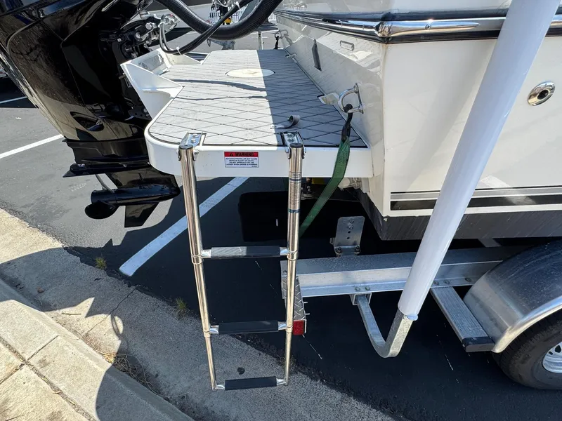 Slide: The Image of 2023 Defiance Admiral 220 EX boat docked in a marina under clear blue skies. - 12