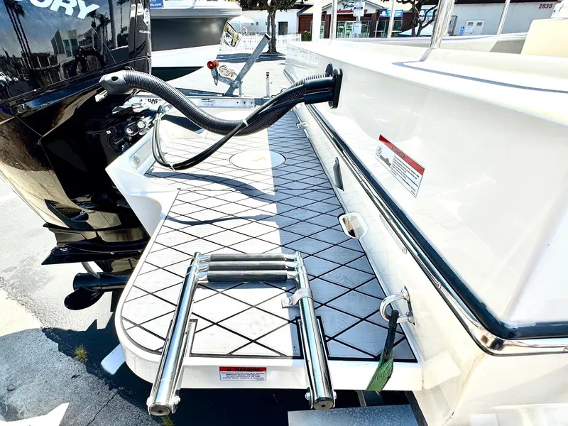 Slide: The Image of 2023 Defiance Admiral 220 EX boat docked at a marina under clear blue skies. - 13