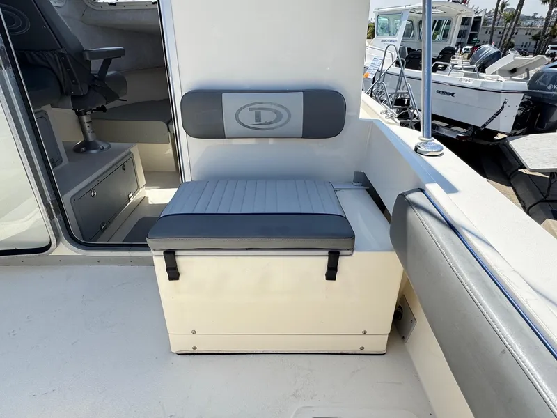 Slide: The Image of 2023 Defiance Admiral 220 EX boat interior with storage hatch and cushioned seating. - 24