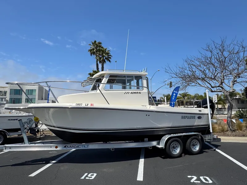 Slide: The Image of 2023 Defiance Admiral 220 EX boat docked at marina under clear sky. - 3