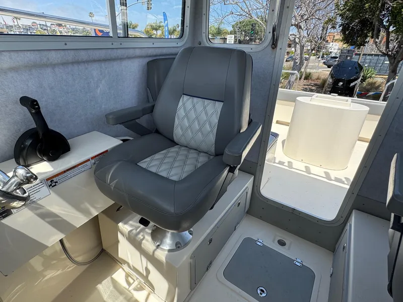 Slide: The Image of Interior of 2023 Defiance Admiral 220 EX boat with gray seating and control panel. - 36