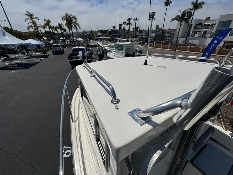 Slide: The Image of 2023 Defiance Admiral 220 EX boat docked at marina, sunny day. - 48