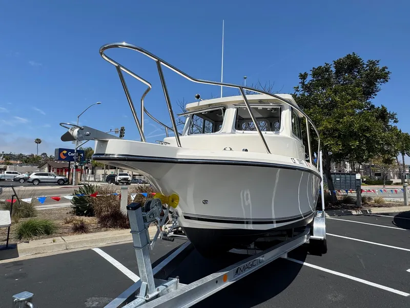 Slide: The Image of 2023 Defiance Admiral 220 EX boat docked at a marina under clear skies. - 5