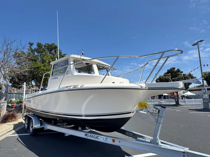 Slide: The Image of 2023 Defiance Admiral 220 EX boat docked at marina under clear blue sky. - 6