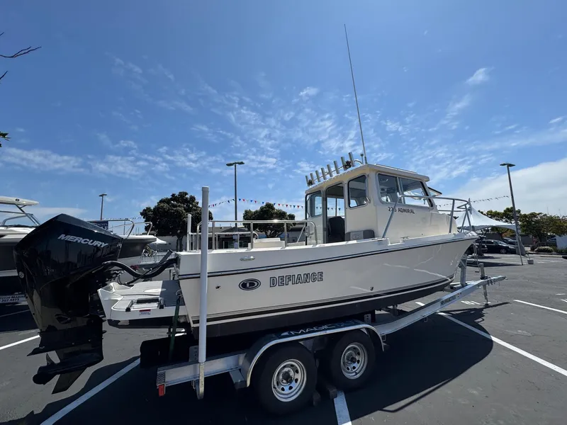 Slide: The Image of 2023 Defiance Admiral 220 EX boat docked at marina under clear blue sky. - 8