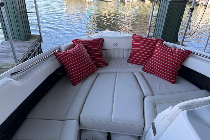 Slide: The Image of 2018 Cobalt R35 boat interior with red striped cushions, docked by the water. - 17