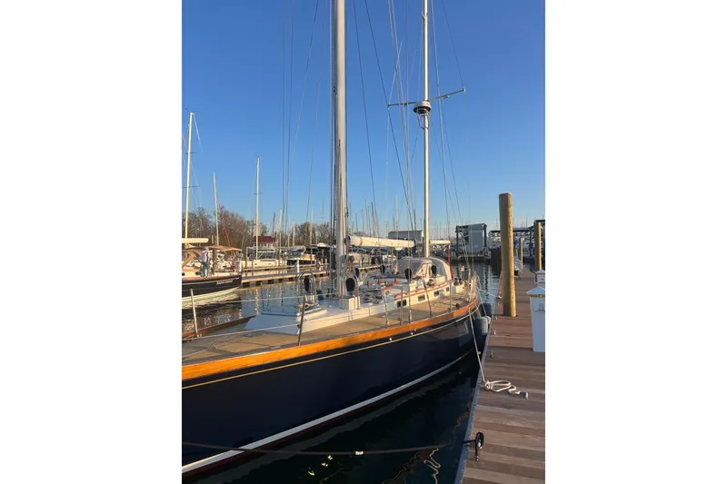 Slide: The Image of 1980 F&C 44 sailboat docked at marina under clear blue sky. - 11