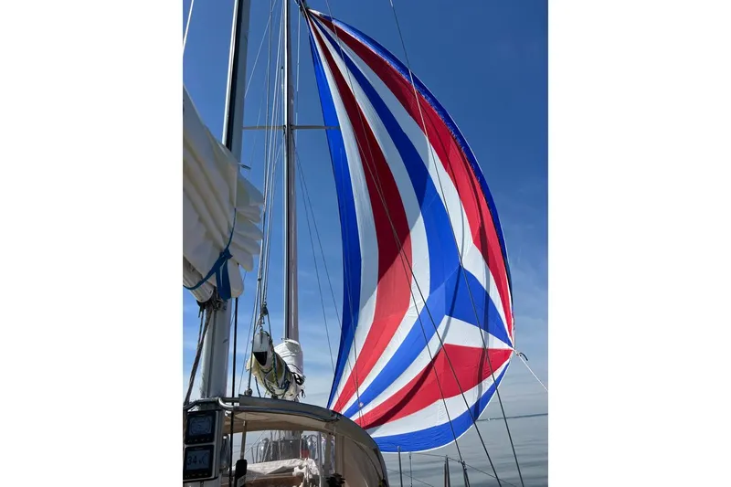 Slide: The Image of Sailboat with colorful spinnaker sail, F&C 44 model, 1980, under clear blue sky. - 14