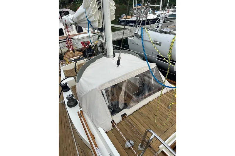 Slide: The Image of 1980 F&C 44 sailboat with covered cockpit, docked at marina. - 16