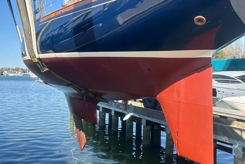 Slide: The Image of 1980 F&C 44 sailboat hull and rudder above water at marina. - 22