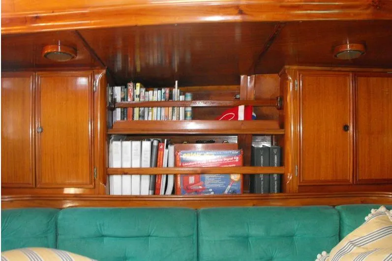 Slide: The Image of Wooden yacht interior with bookshelves and green seating, F&C 44, 1980 model. - 26