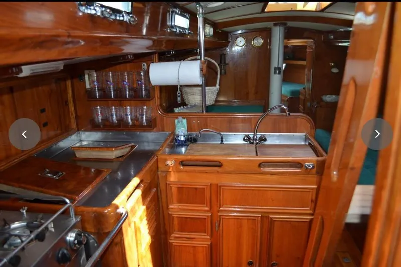 Slide: The Image of Interior of 1980 F&C 44 yacht featuring wooden cabinetry and compact kitchen area. - 28