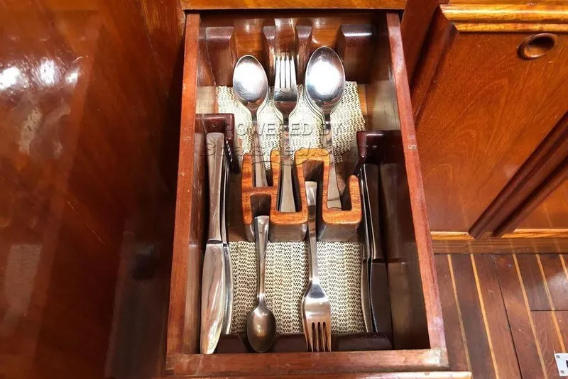 Slide: The Image of Wooden drawer with organized cutlery, featuring spoons, forks, and knives in a vintage F&C 44 model. - 29